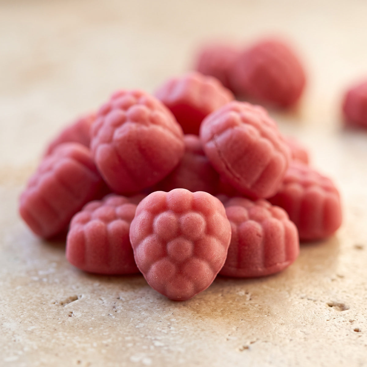 Gros plan sur les gummies rose framboise, forme moulée mate